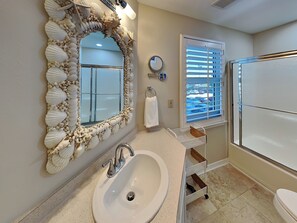 A bathroom with a large mirror, sink, and toilet. - South Harbour #2F by Southern Vacation Rentals (Pensacola Beach)