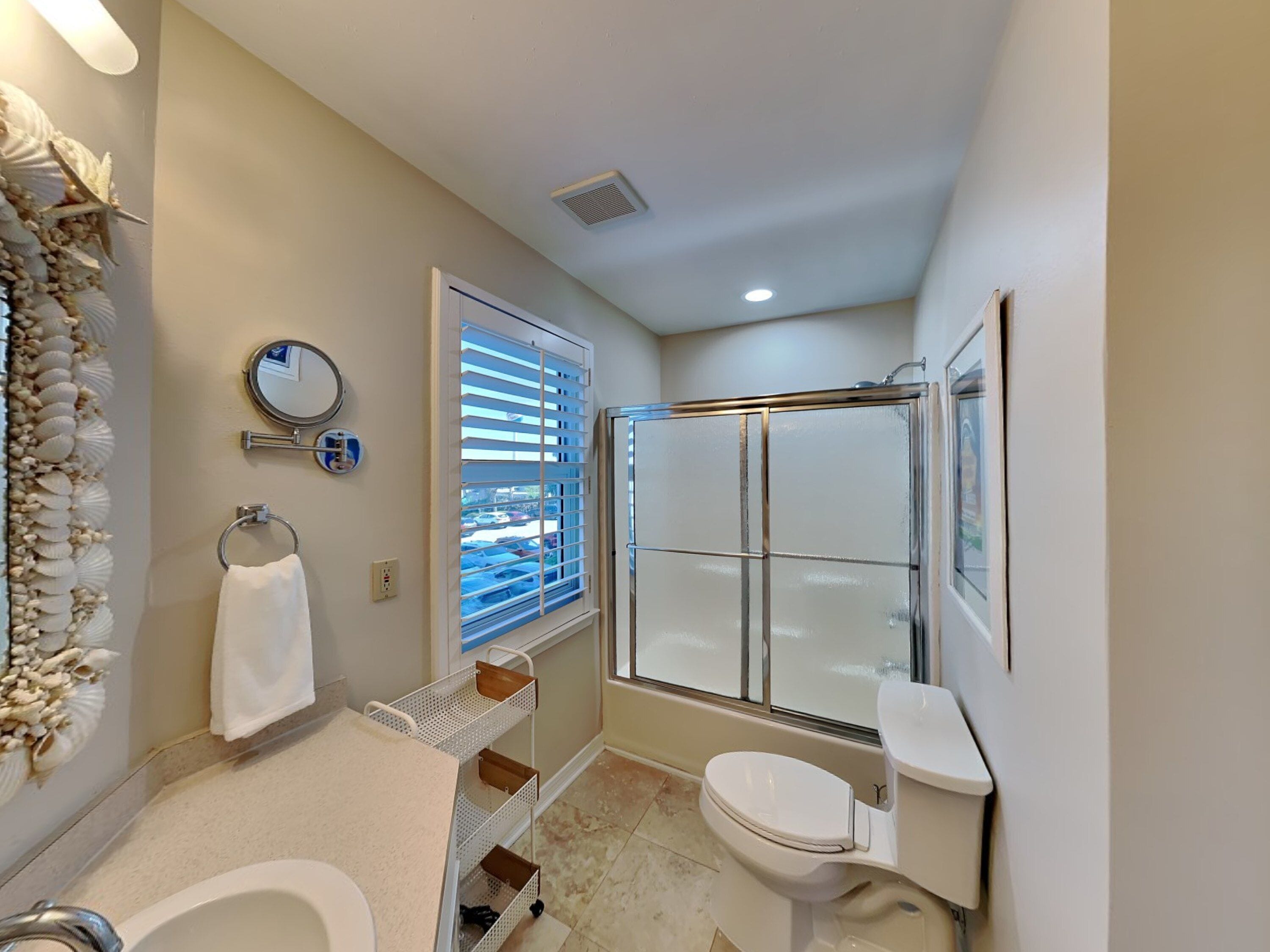 A bathroom with a bathtub, toilet, and a glass-enclosed shower.