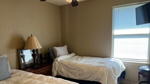 A bedroom with two beds, a nightstand, a lamp, a mirror, and a window with blinds. - Best Stays@ La Meza Roja, Wifi, Pet Friendly (Tyler)