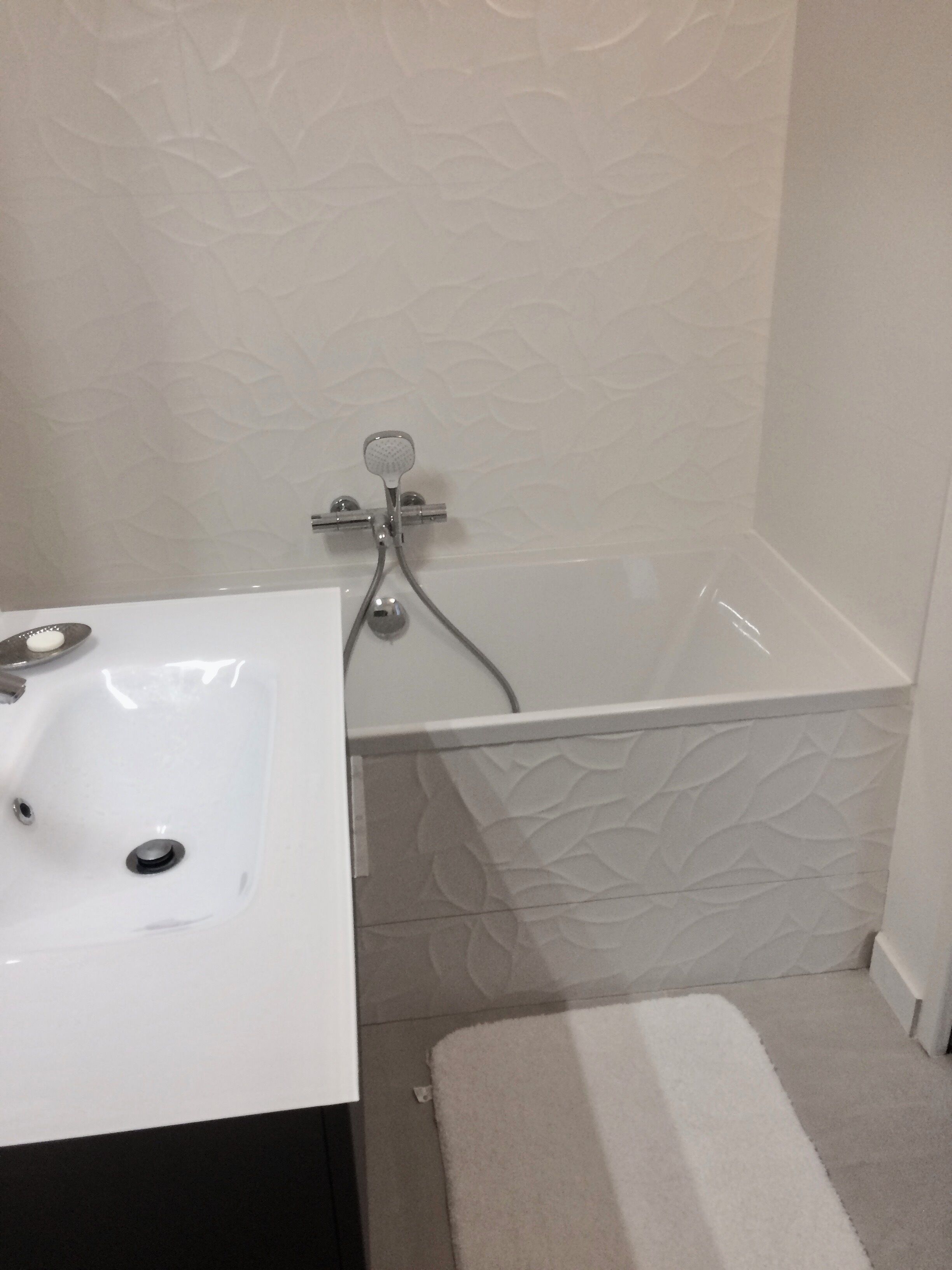 Une salle de bain avec un lavabo blanc, une baignoire et une douche.
