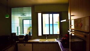 A kitchen with a window, sink, and appliances. - Terrasses sur la mer (Sète)