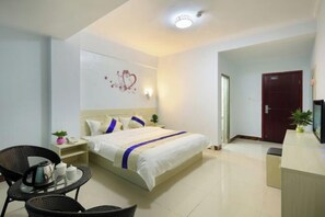 A hotel room with a bed, a desk, a chair, and a small table with a kettle and cups. - Sanya Haitang Bay Rujia Hotel (Sanya)
