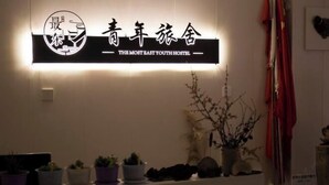 A sign for "The Most East Youth Hostel" with a modern design, featuring a logo and bilingual text.
