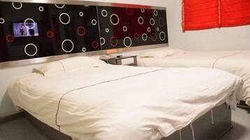 Une chambre d’hôtel avec deux lits, un décor mural moderne et un store rouge aux fenêtres.