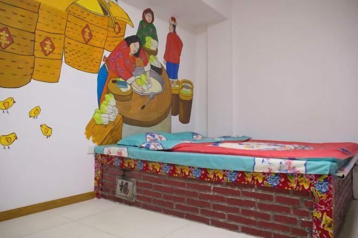 Ein Kinderzimmer mit Bett, Ziegelwand und Wandgemälde.