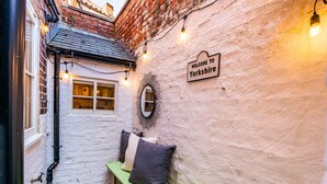 A narrow alleyway with a bench, a 'Welcome to Yorkshire' sign, and a wall-mounted mirror.