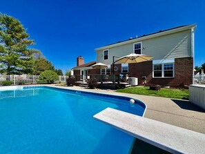 Une piscine résidentielle avec une maison en arrière-plan.