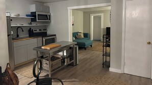 A compact living space with a kitchenette, a sofa, and a TV.
