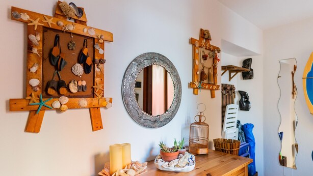 A wooden dresser with a mirror, potted plants, and decorative items. - Casa Aprilia by Ca-sa Check (Venice)