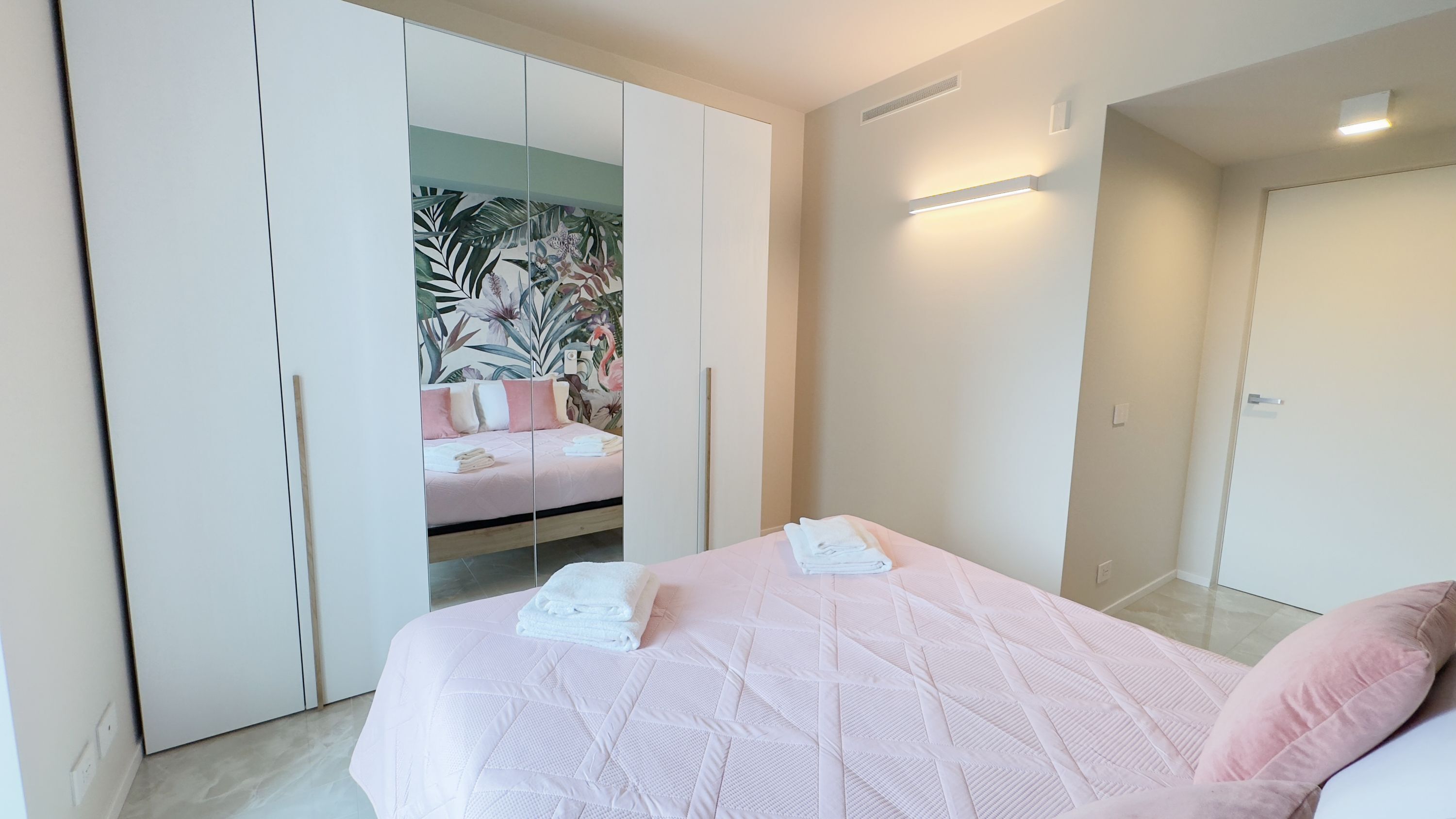 Ein Schlafzimmer mit Bett, Kleiderschrank und Bad.