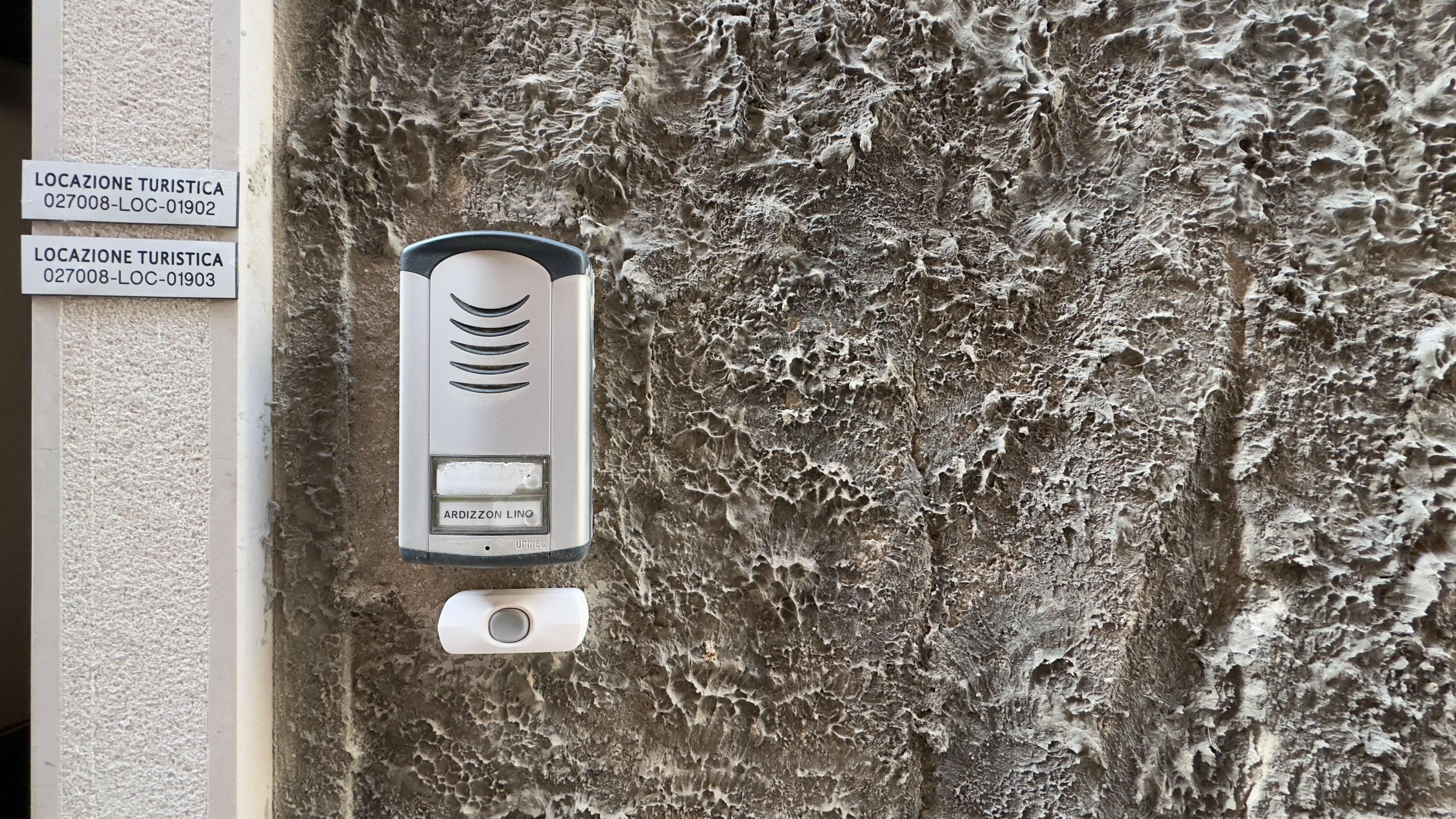 Intercom empotrado en la pared con dos indicaciones que señalan puntos de información turística.