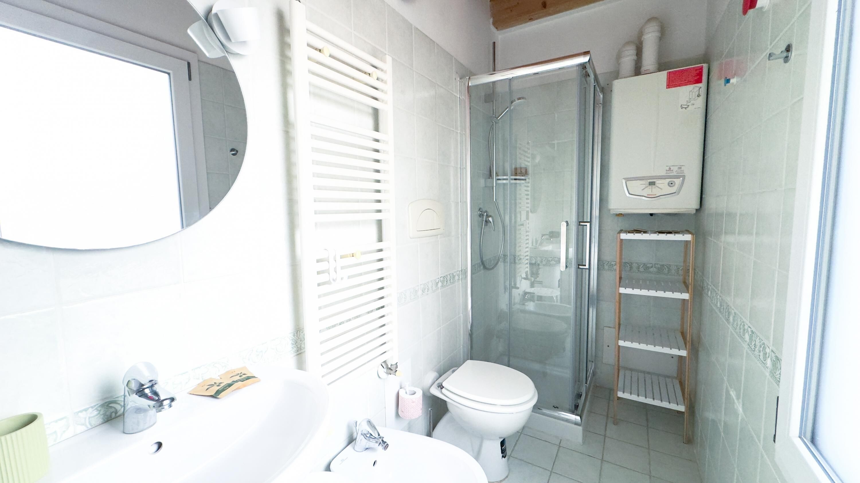 A bathroom with a toilet, sink, and shower.