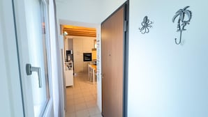 Un corridoio che porta a una cucina con mobili in legno e una zona pranzo.