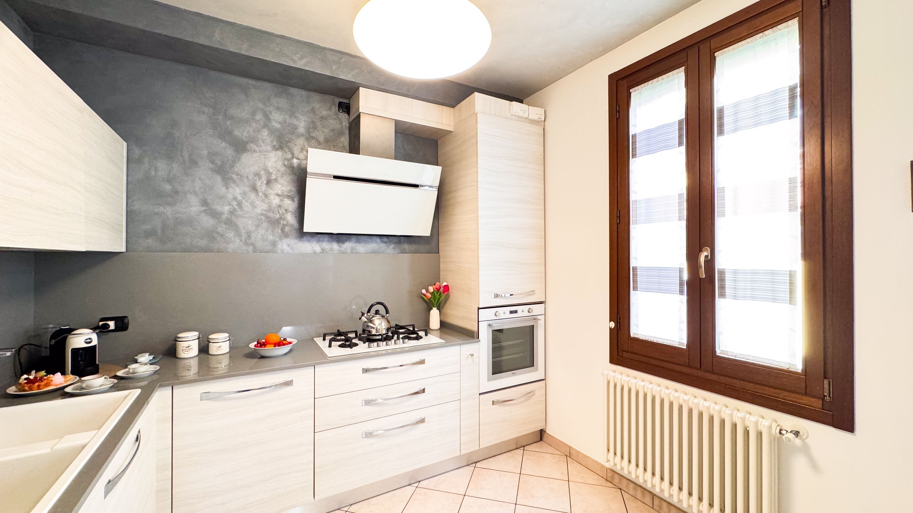A modern kitchen with a gas stove, oven, and white cabinetry.