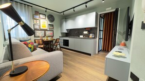 A modern apartment with a living room, dining area, and kitchen.