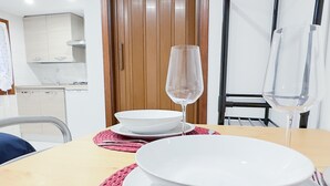 A dining table with white plates and a wine glass, set on a woven placemat. - Blue Eyes by Ca-sa Check (Chioggia)