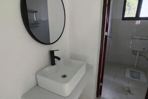 A bathroom with a white sink, black faucet, and a mirror. - Shennong Valley Xishui Hotel (Yanling)