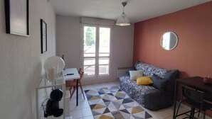 A compact living space with a sofa, a dining table, and a small kitchenette area. - Charming studio in Avignon (Avignon)