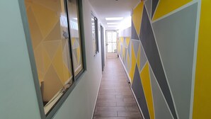 Ein Korridor mit geometrischen Wandmustern und Fliesenboden.