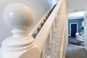 Un escalier doté d’une balustrade blanche et de balustres ronds.