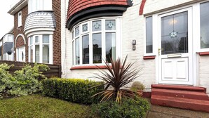 A residential building with a white facade, a bay window, and a red door. - Comfortable 3 Bedroom Home Sleeps 5 (Stockton-on-Tees)