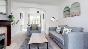 A living room with a fireplace, a sofa, a coffee table, and a lamp. - Comfortable 3 Bedroom Home Sleeps 5 (Stockton-on-Tees)
