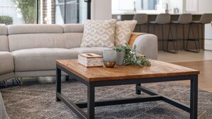 A living room with a sofa, a wooden coffee table, and a rug.