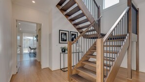 A staircase with wooden steps and metal railings leading to an upper floor.