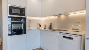 Eine moderne Küche mit eingebauten Geräten, darunter eine Mikrowelle, ein Backofen und ein Geschirrspüler.