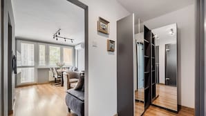 Un intérieur moderne comprenant un coin repas, un canapé et un placard avec des portes miroir.