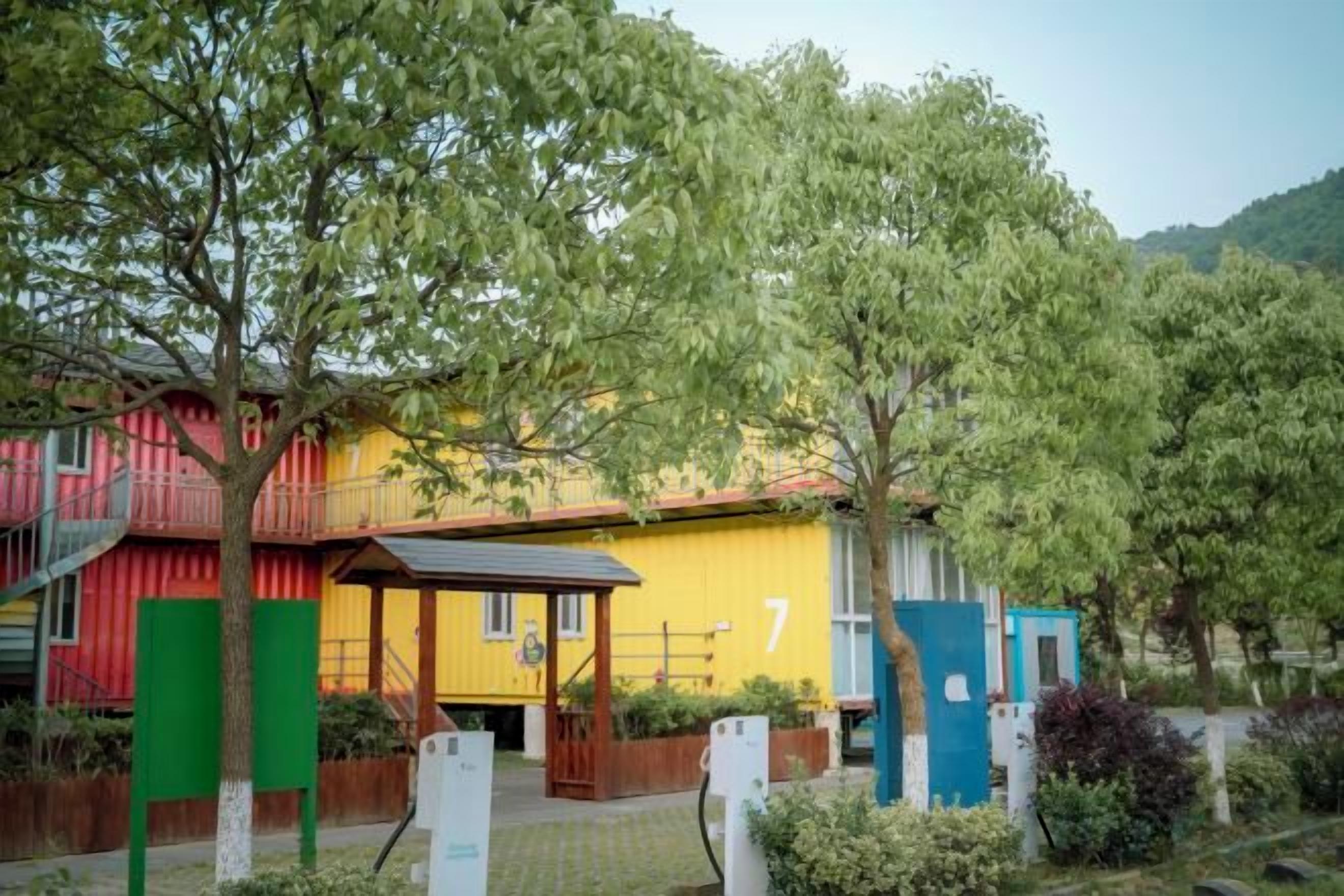 Un edificio colorido con un letrero con el número 7, rodeado de árboles y follaje.
