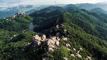 Un paisaje montañoso con un camino serpenteante y afloramientos rocosos.