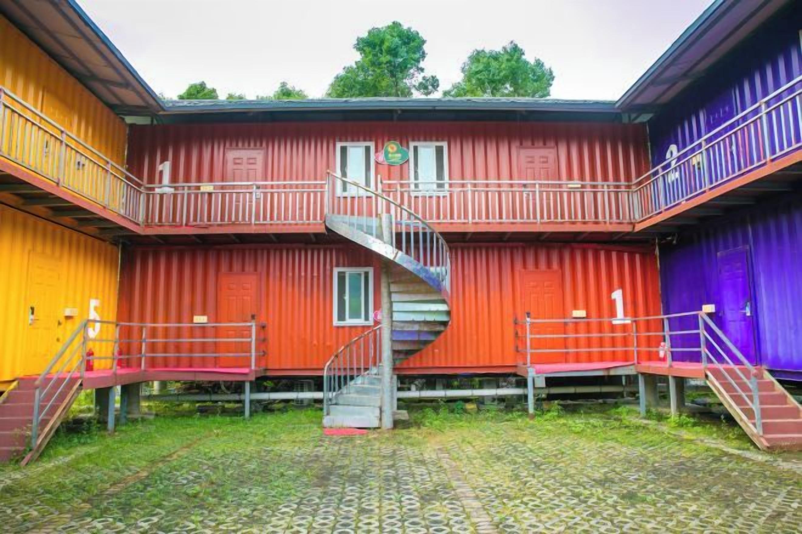 A multi-level building with a spiral staircase, outdoor stairs, and a fenced area.