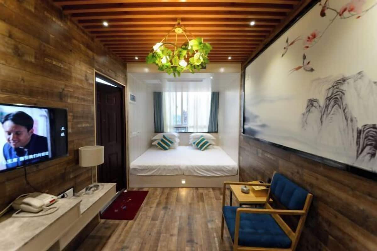 Une chambre avec un lit, une télévision, un bureau et une chaise.