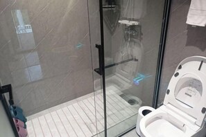A modern bathroom with a glass shower enclosure, a white toilet, and a tiled floor. - Anqing Jushishan LOVE Homestay (Anqing)