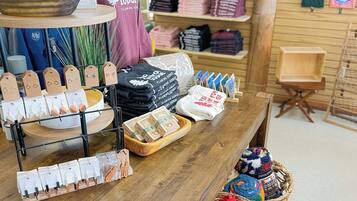 A retail display with various items including hats, t-shirts, and gift bags.