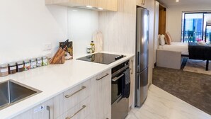 Eine moderne Küche mit hellen Holzschränken, einem Edelstahlkühlschrank und einem eingebauten Backofen.