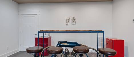 Ein Zimmer mit einem blauen Fahrrad, zwei Hocker, einem roten Schrank und einer weißen Tür.