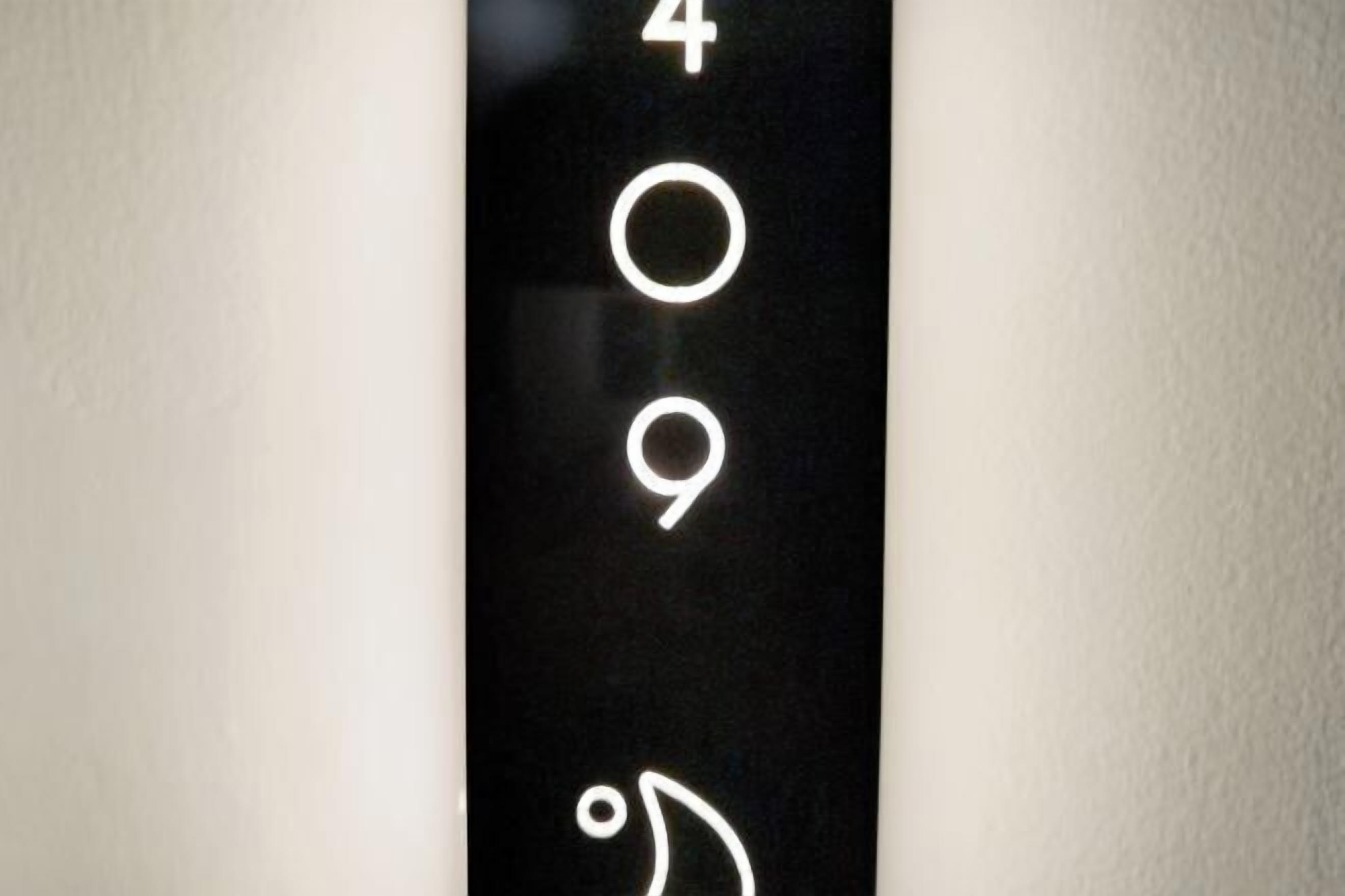 A black wall with white numbers and a symbol indicating room number 409.
