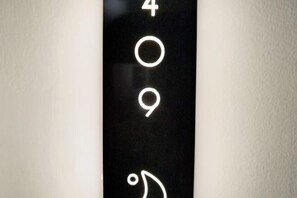 A black wall with white numbers and a symbol indicating room number 409.
