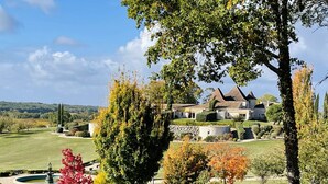 A large house with a stone facade and a tiled roof, surrounded by a well-maintained lawn and trees. - Elegant Wine Estate: Stunning Views, Heated Pool & Wi-Fi (Fougueyrolles)