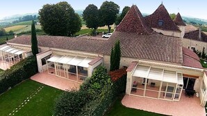 A large estate with multiple buildings, including a main house with a tiled roof and several smaller structures with glass enclosures. - Elegant Wine Estate: Stunning Views, Heated Pool & Wi-Fi (Fougueyrolles)