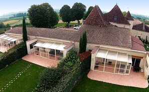 A large estate with multiple buildings, including a main house with a tiled roof and several smaller structures with glass enclosures.