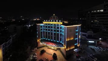 A multi-story building with a central stage and seating area, surrounded by a parking lot.