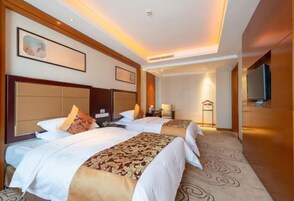 Habitación de hotel con dos camas, un espejo grande y un televisor.