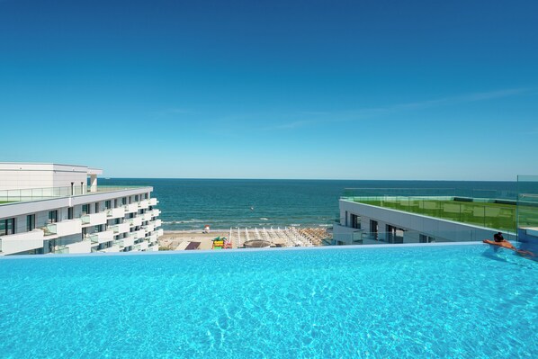 季节性开放的室外游泳池，池畔遮阳伞，日光浴躺椅