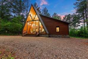 A modern wooden cabin with a triangular roof, large windows, and a stone foundation. - An A-Frame with some SASS and southwestern CLASS! (Broken Bow)