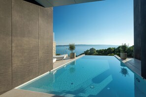 A modern infinity pool with a clear view of the sea and distant mountains. - Villa Brela-Rogac1 (Brela)