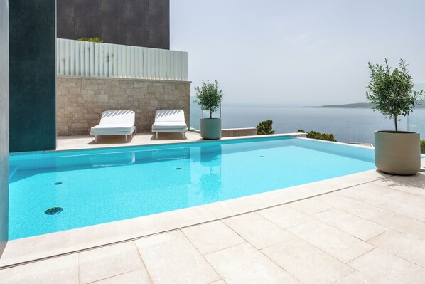 Outdoor pool, a heated pool, pool umbrellas, pool loungers