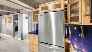 Una cocina con armarios de madera, un refrigerador de acero inoxidable y una encimera azul.